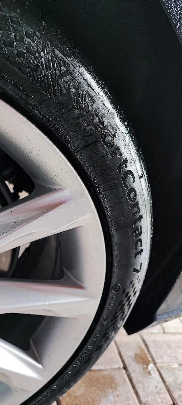 Nahaufnahme einer Reifenflanke mit der Aufschrift Continental SportContact auf einer Aluminiumfelge