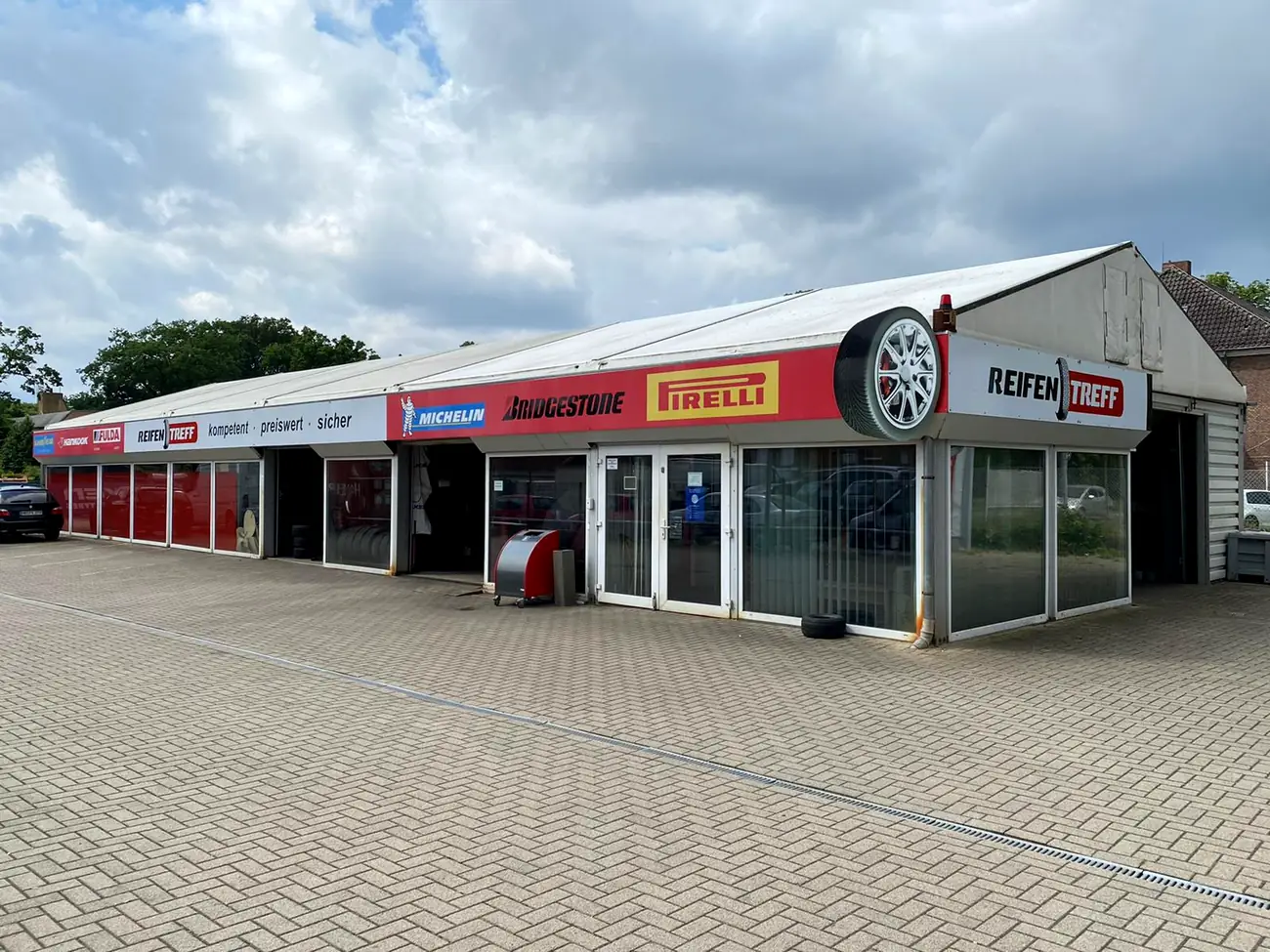Gesamtansicht der Halle vom Reifen Treff mit dem großen Rad auf der Dachecke