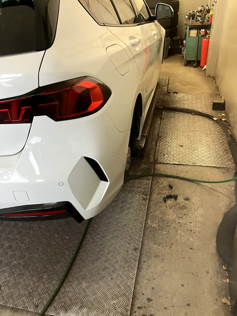 Ein Auto steht zum Reifenwechsel in der Werkstatthalle vom Reifen Treff